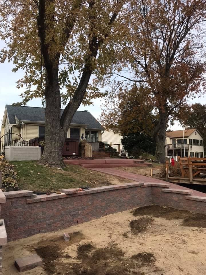 Multi-level brick retaining wall with stamped concrete walkway and steps