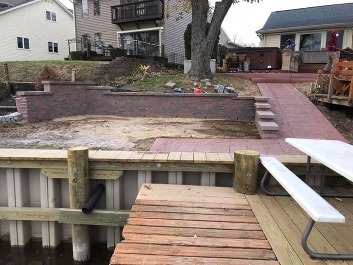Retaining wall with steps connecting dock to paver patio at waterfront home