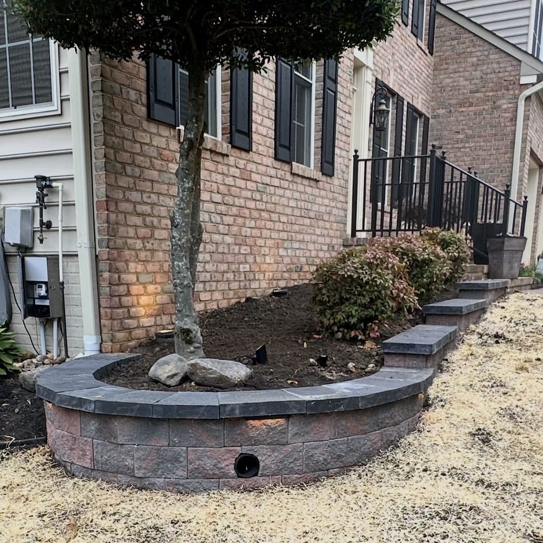 Stone block retaining wall with steps at residential home